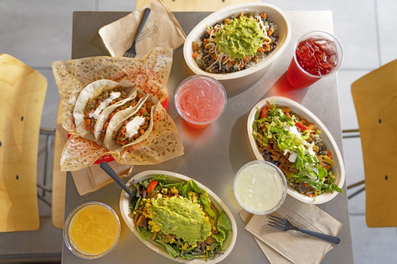 A table full of Chipotle food items and drinks.