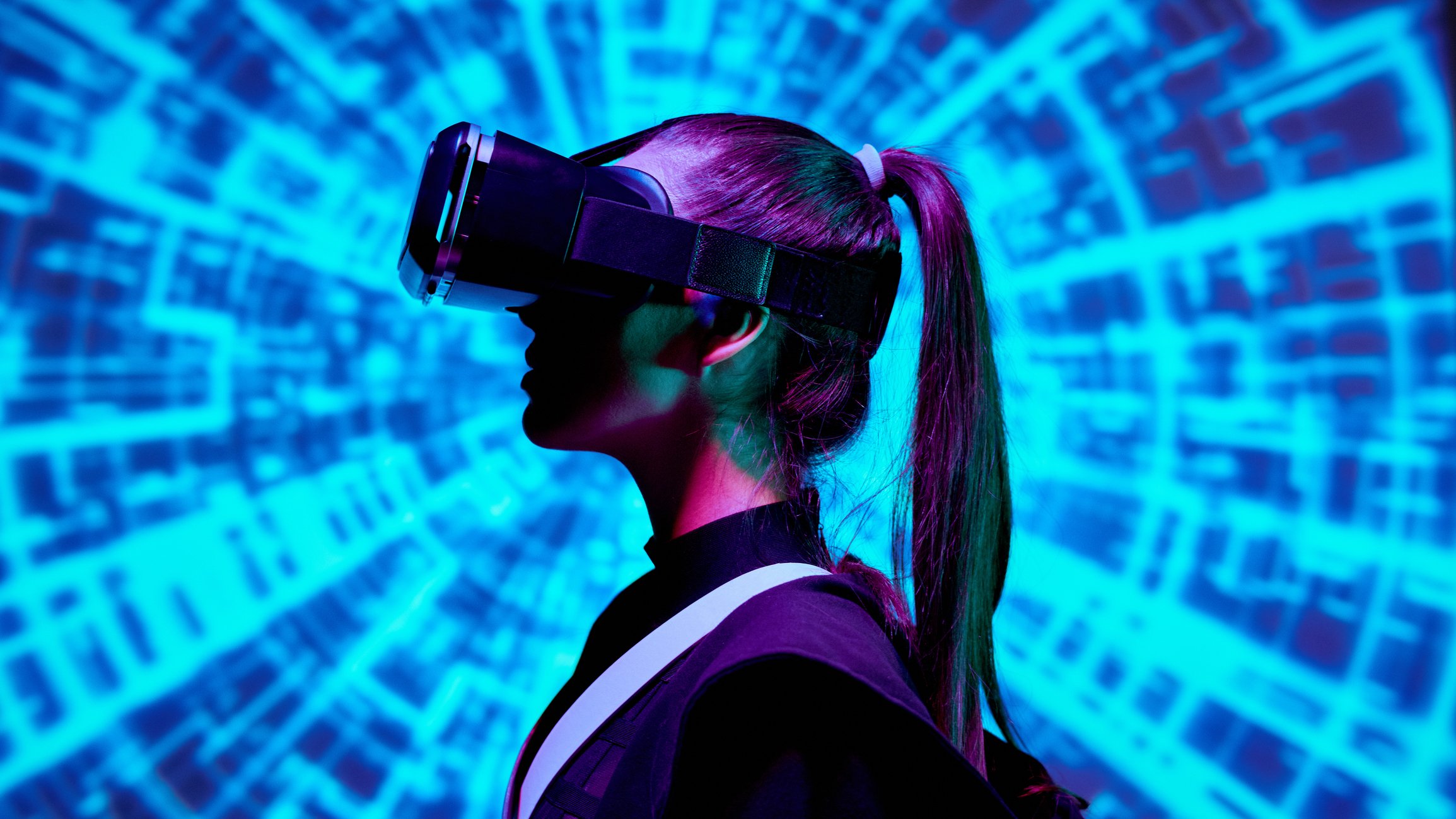 Woman wearing VR headset with blue digital background. 