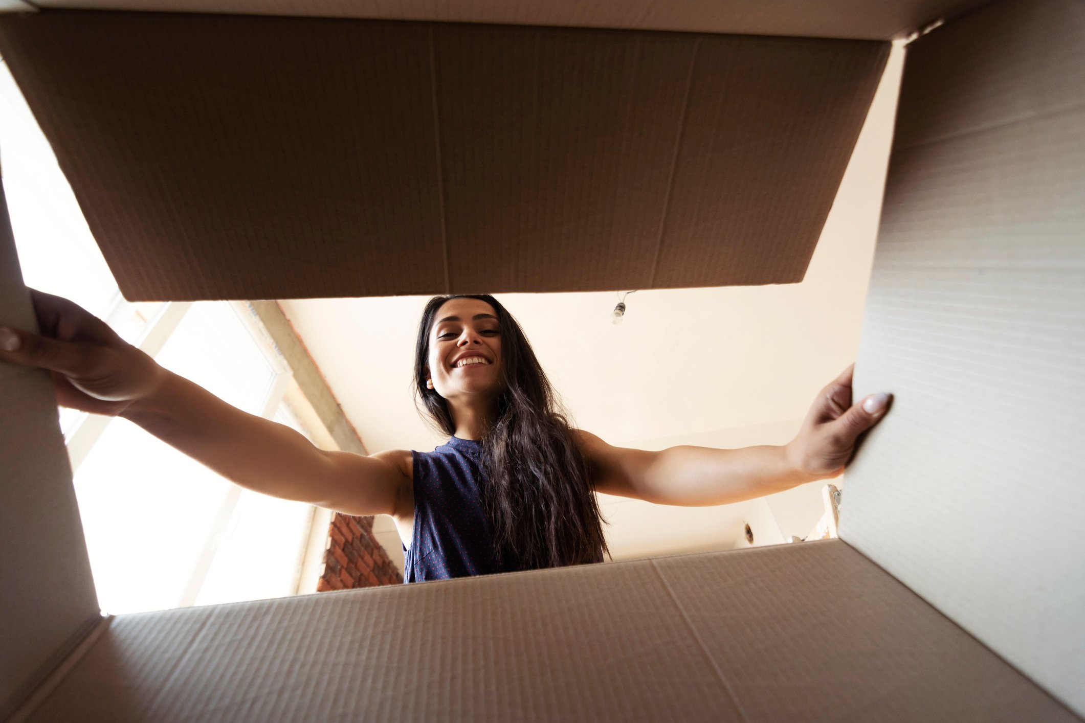 A woman looking into a cardboard box.