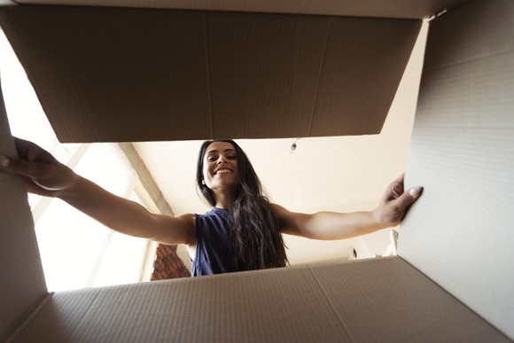 A woman looking into a cardboard box.