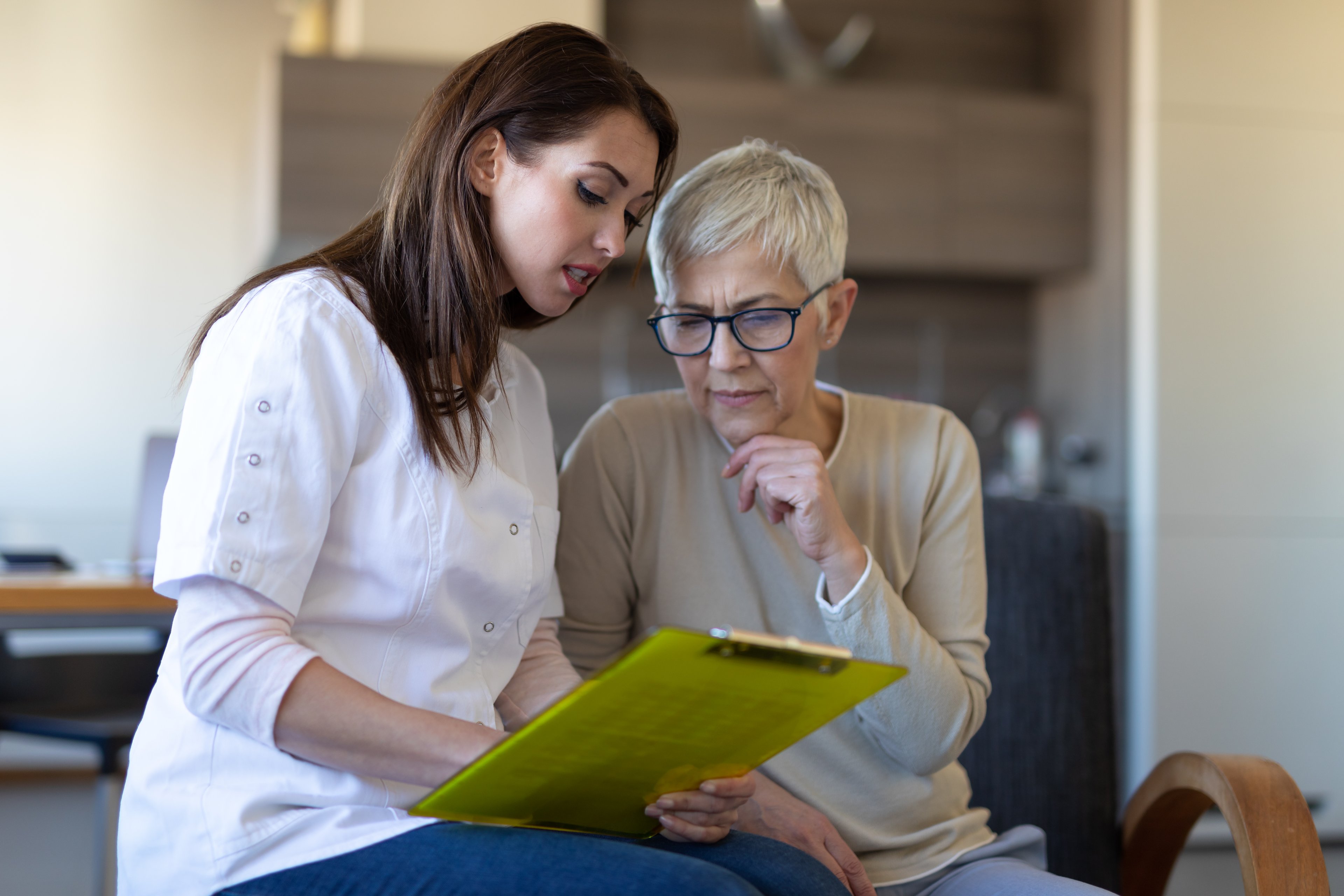 A medical assistant helps a woman with paperwork.