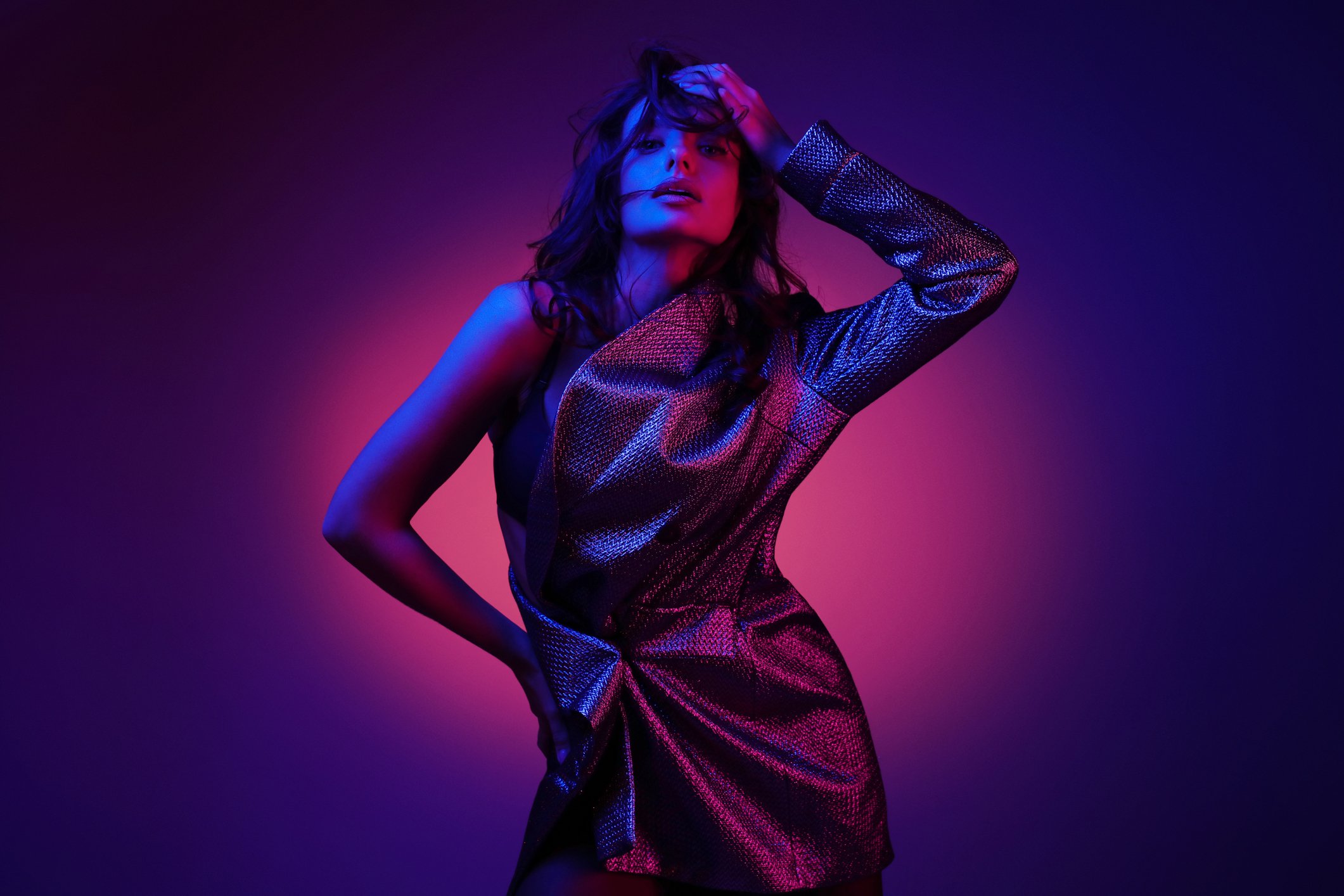 Fashion model in stylish clothing with neon lights in studio.