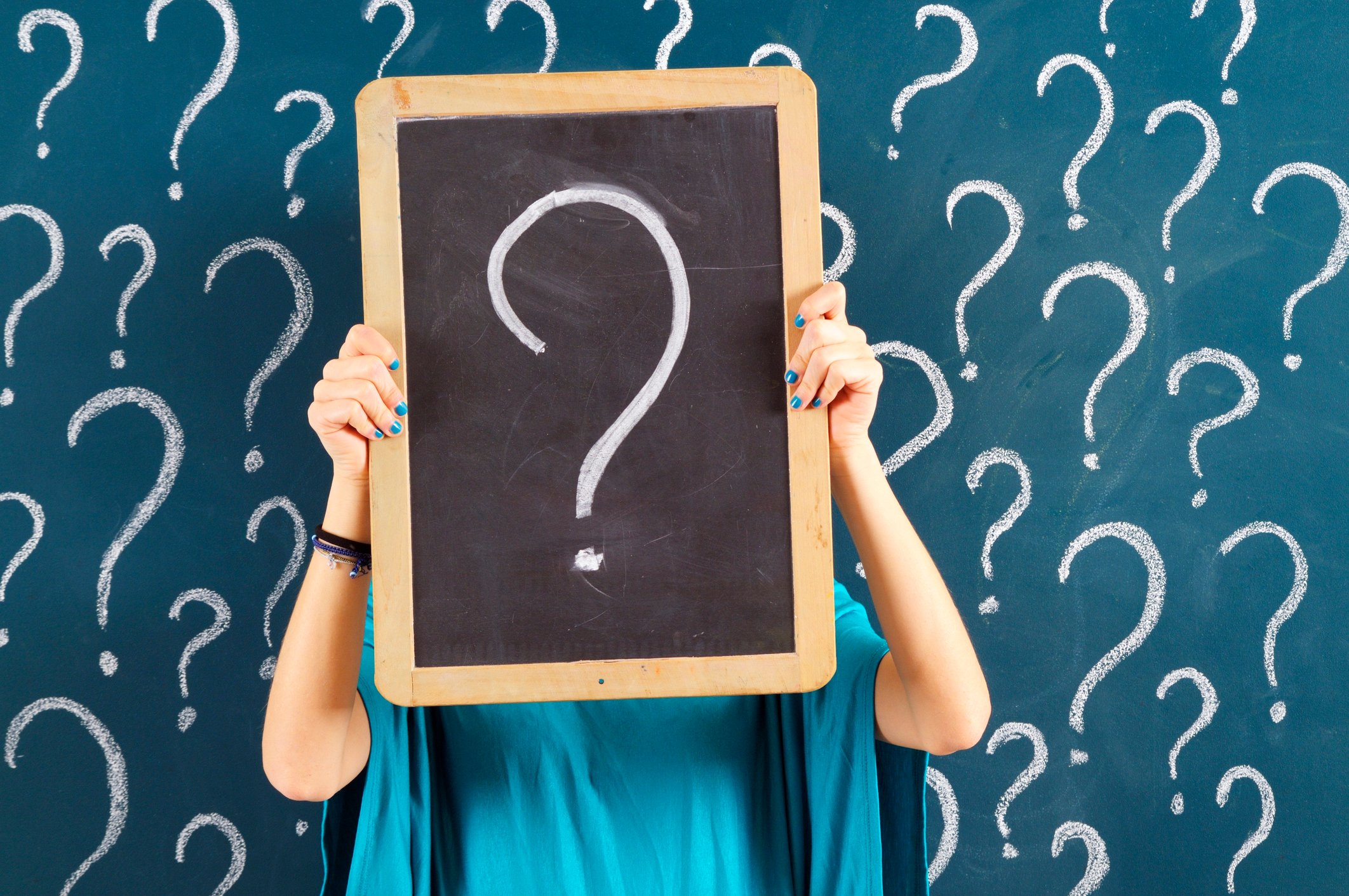 Woman holding chalkboard with question mark.