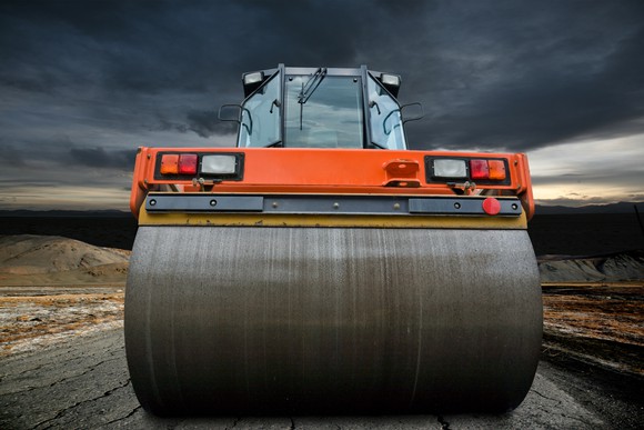 A steamroller with dark clouds in the background