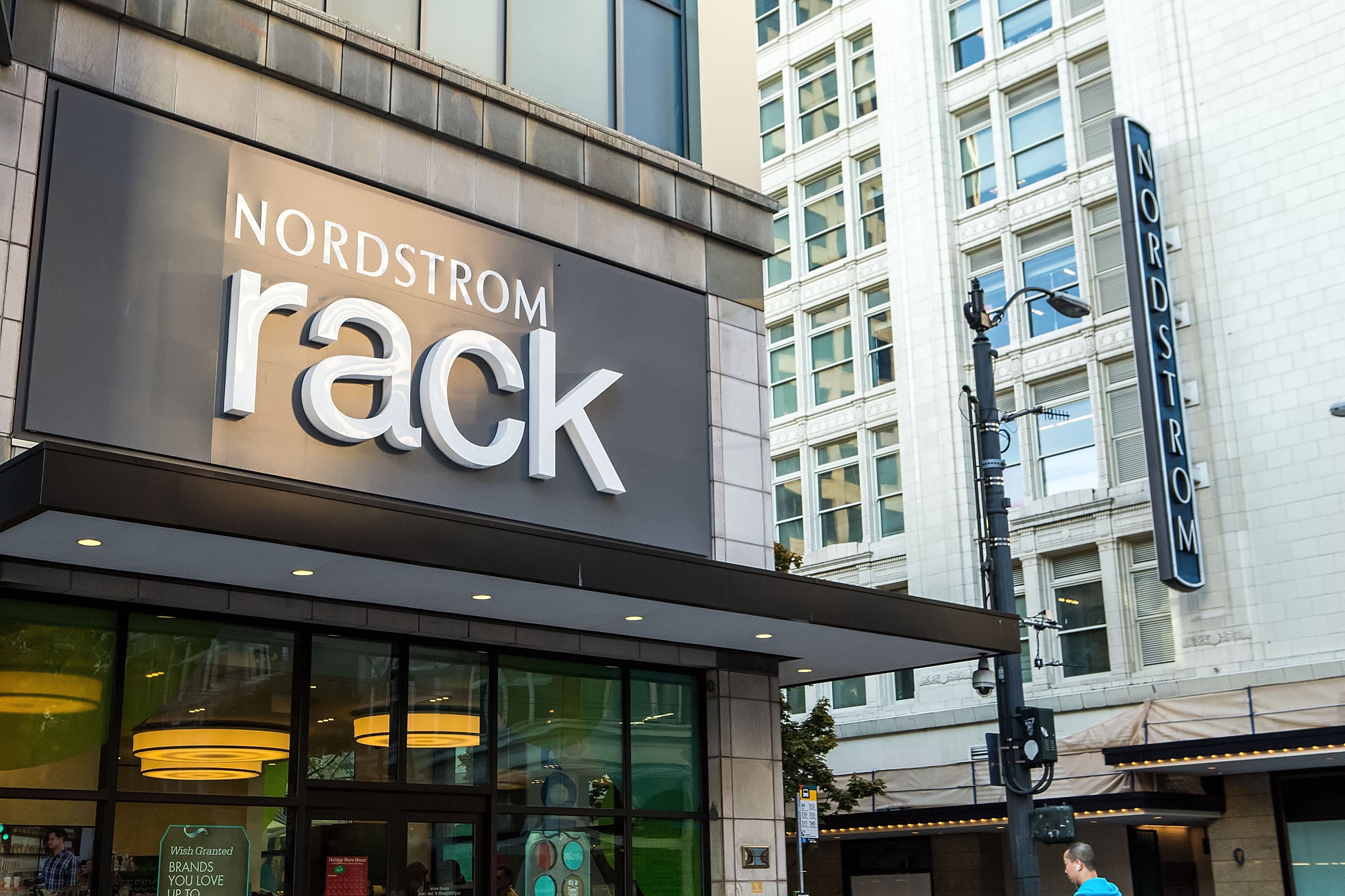 The entrance to a Nordstrom Rack store, with the Nordstrom Seattle flagship store in the background