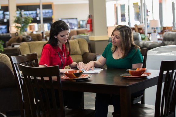Rent-A-Center employee and customer looking at papers