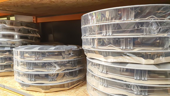 Shrink-wrapped car wheel rims on a shelf.