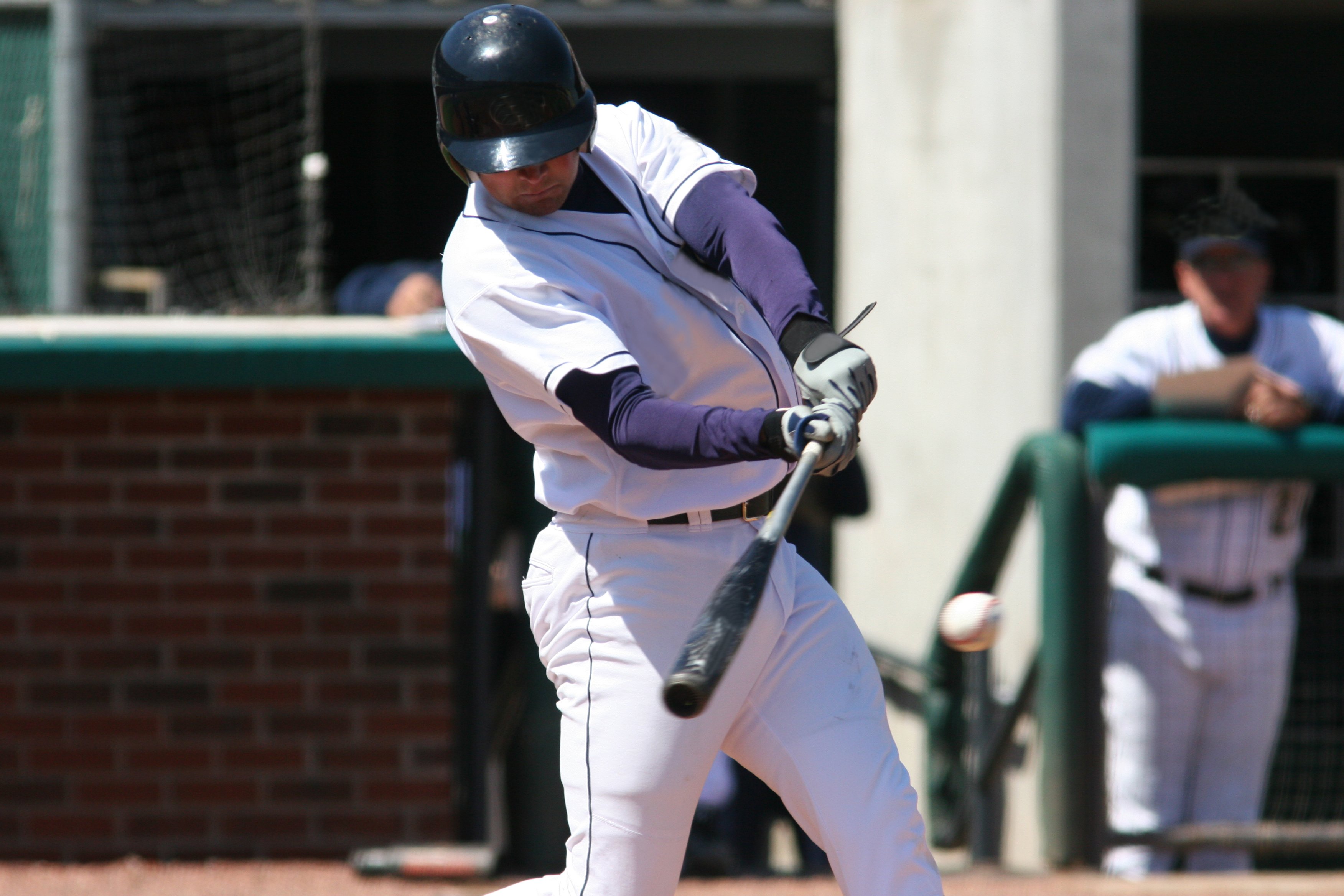 Baseball batter hitting a pitch.