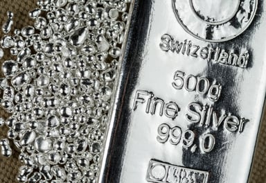 A silver bar beside a pile of silver grains.