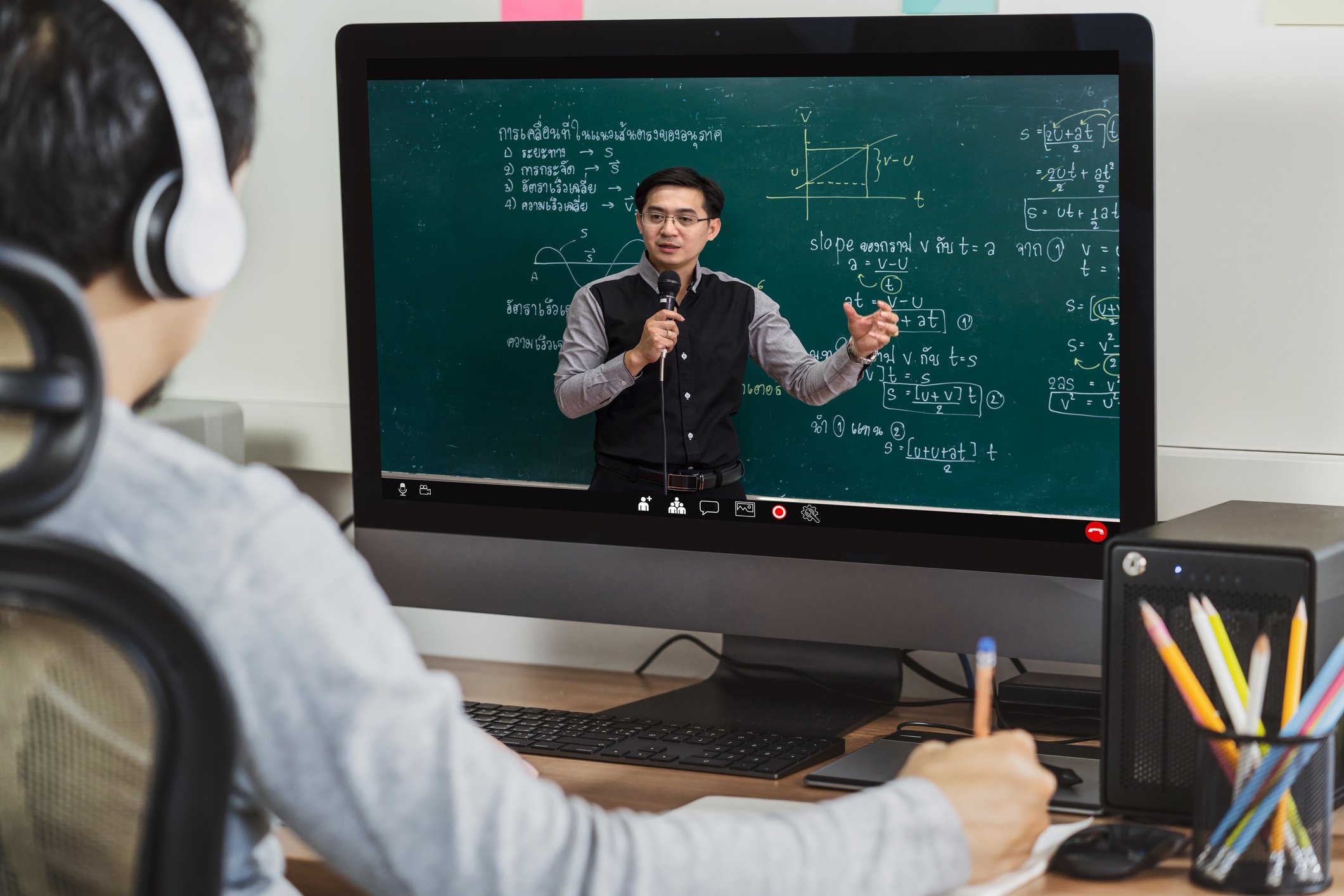 a student watches an online lecture on his desktop. 