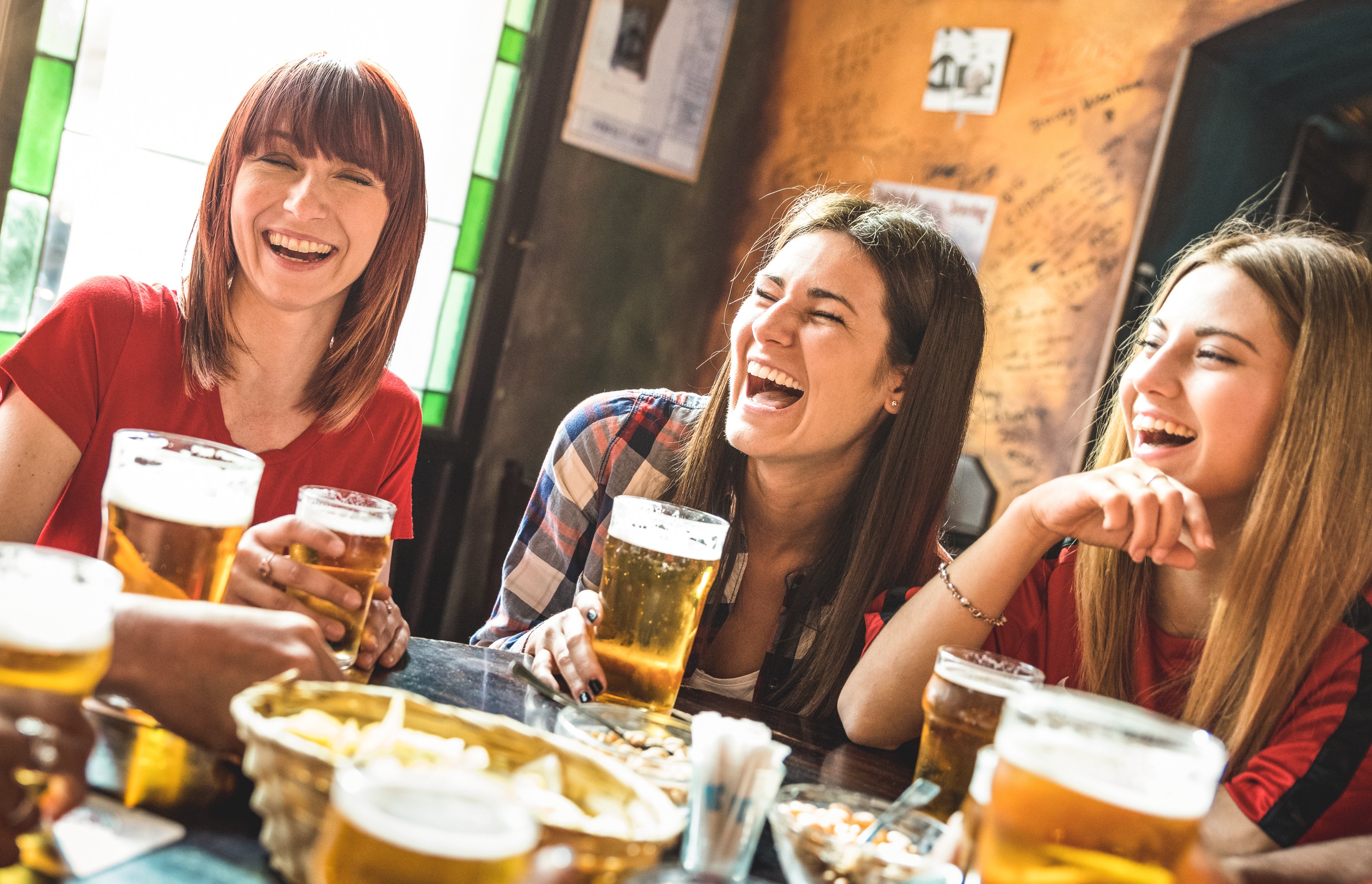 Friends sharing a beer at a bar.