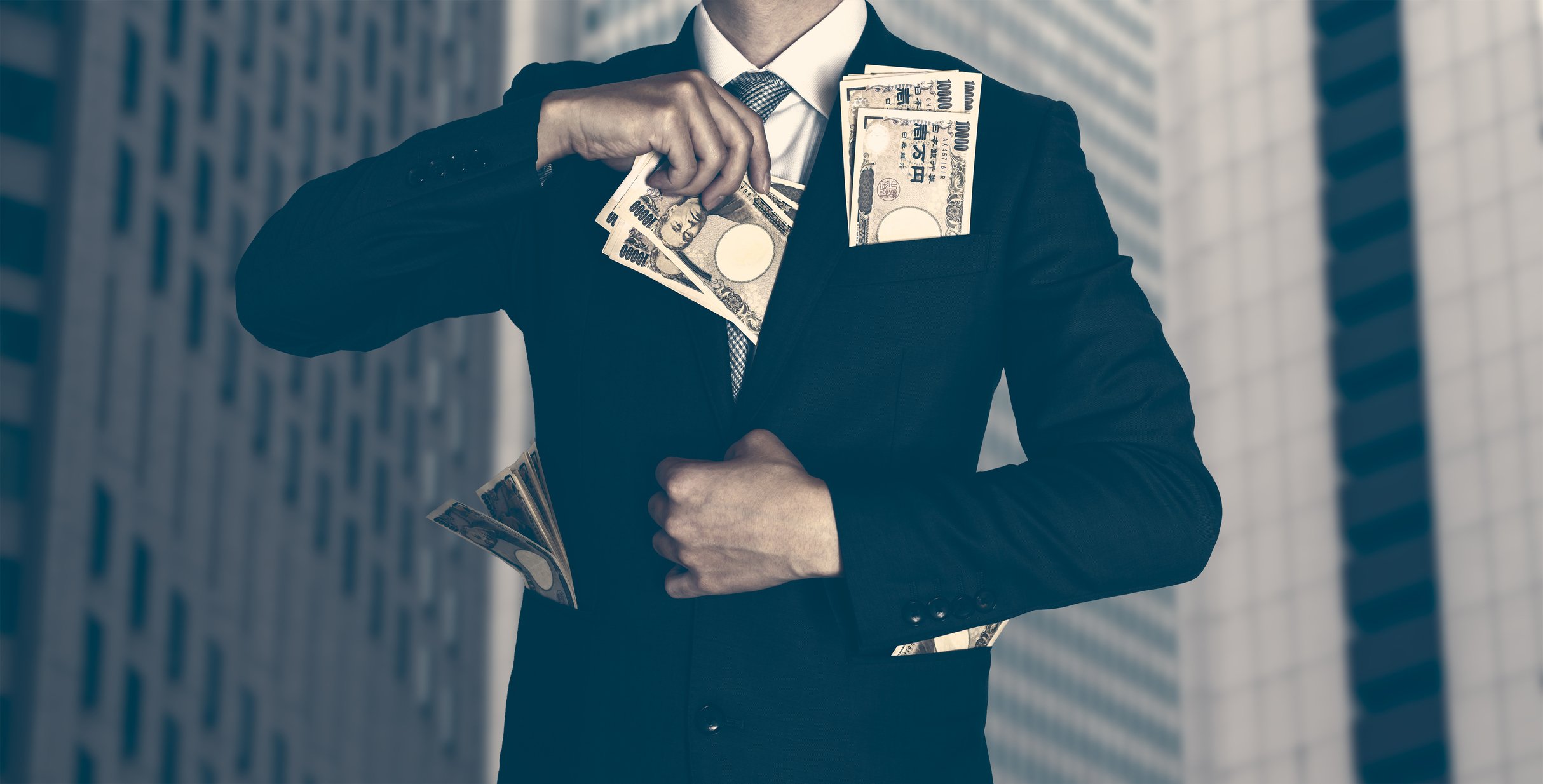 Man stuffing cash into his suit.