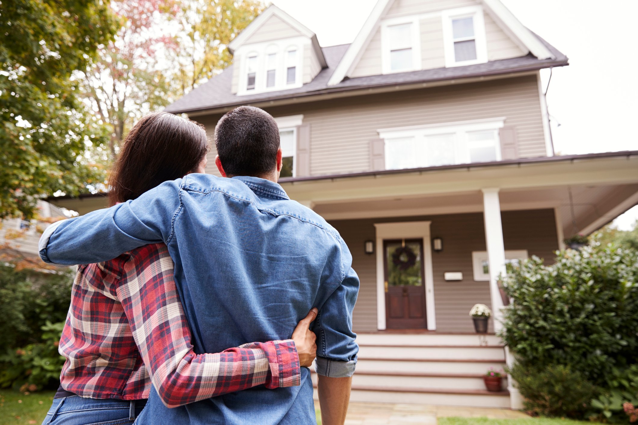 A couple looking at a home they bought. 