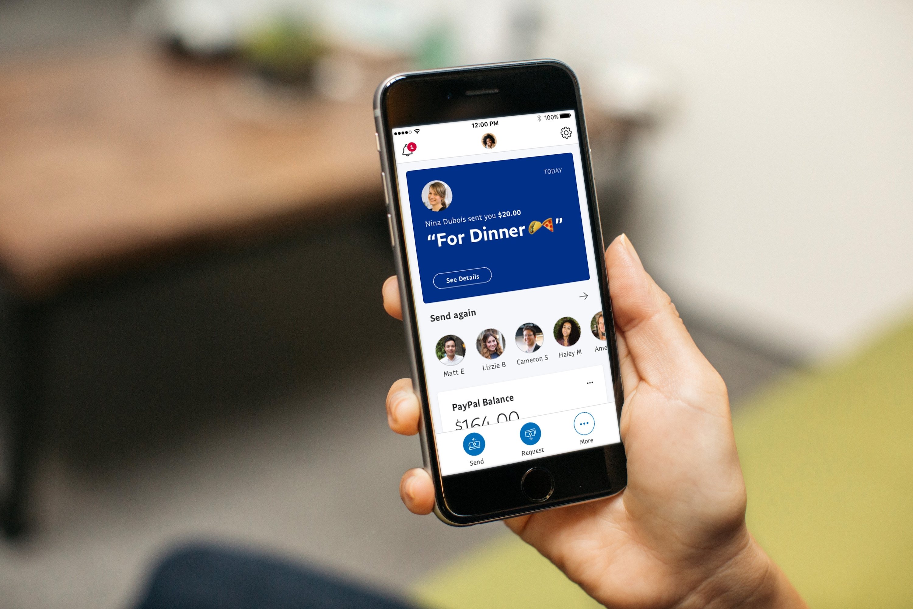 Person holding a phone using the PayPal app