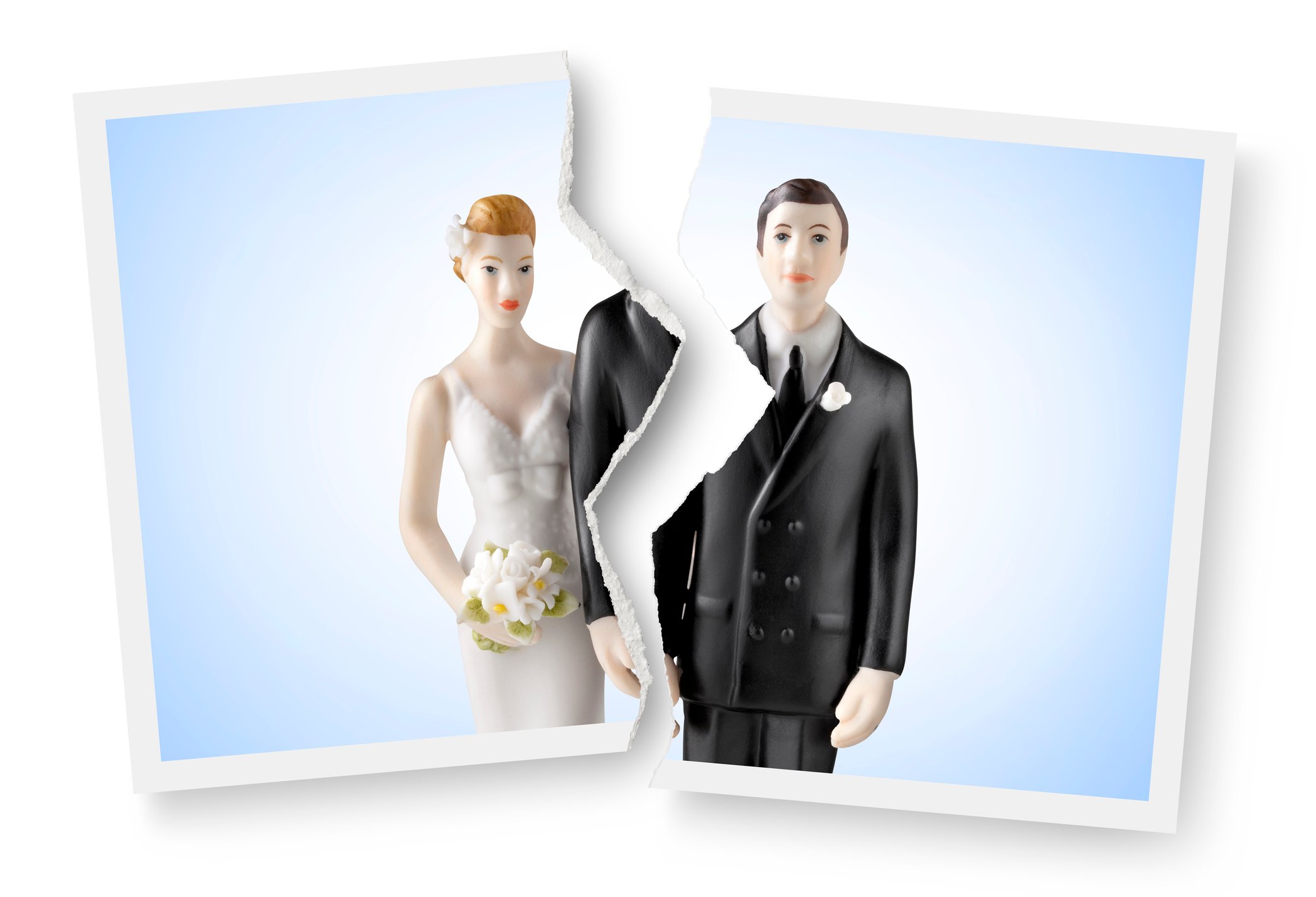 A photograph of a wedding cake topper is torn in half.