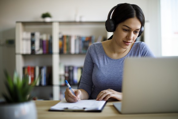 A young woman takes an online course on her laptop.