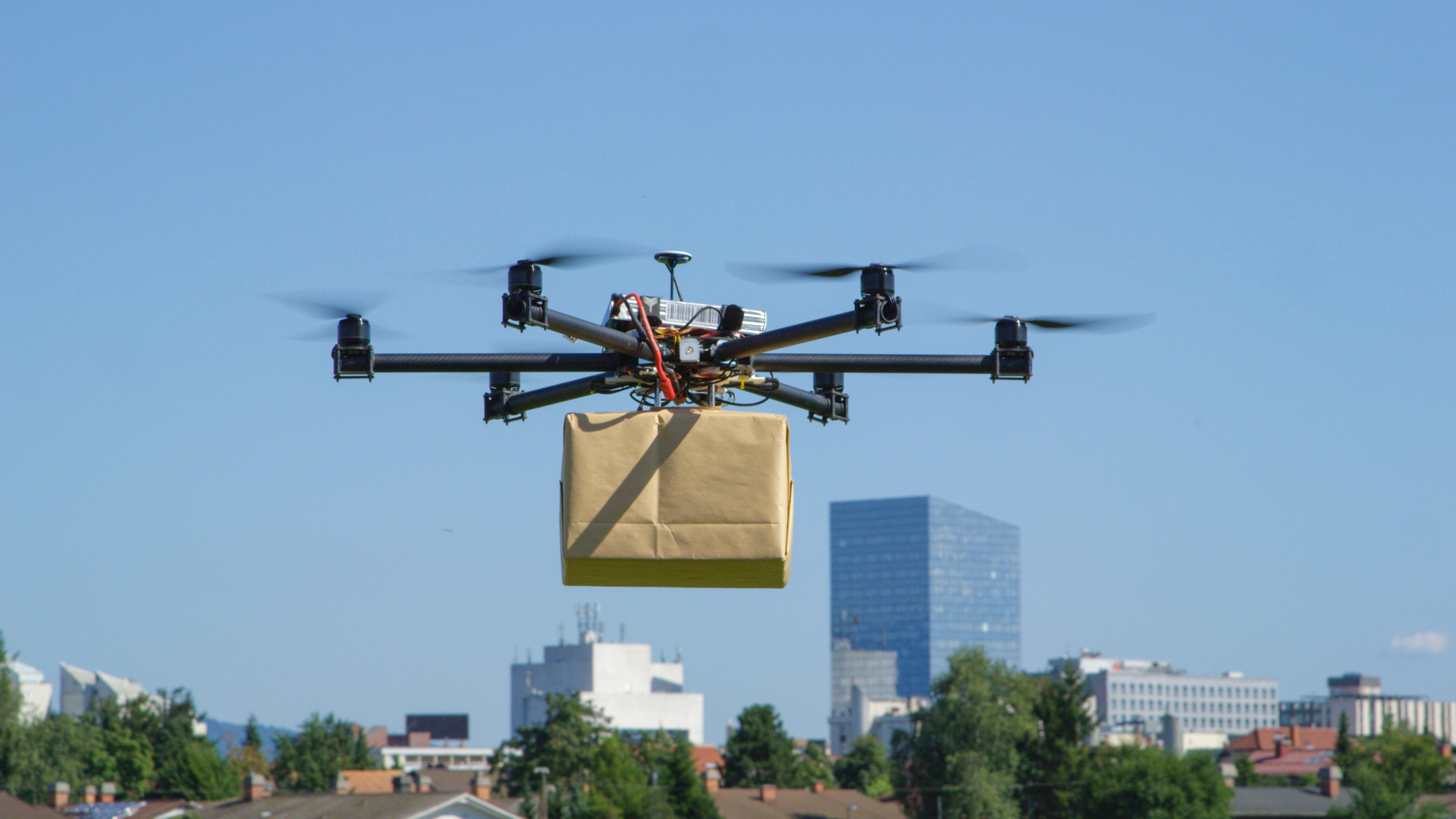 A drone carrying a cardboard box