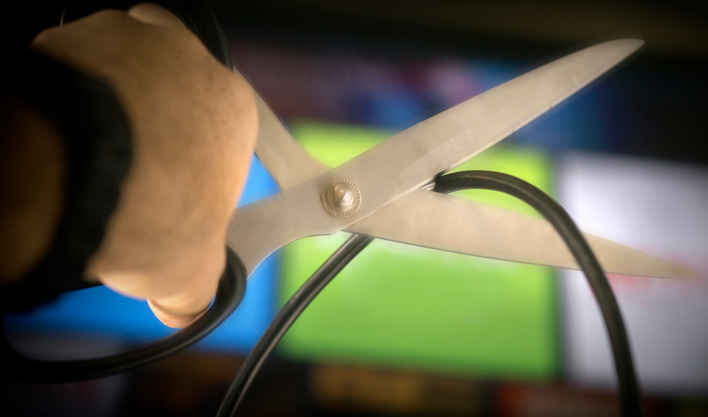 A pair of scissors about to cut a cable.