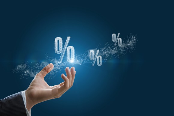 Three percentage signs emanating from a person's open palm.