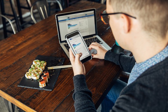 Man checking stocks on laptop and phone