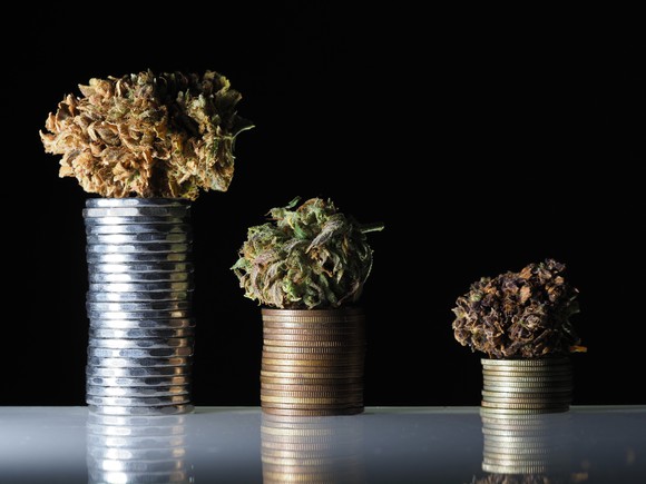 Medical marijuana buds on stack of coins.