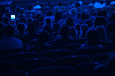 Audience in a darkened theater in silhouette