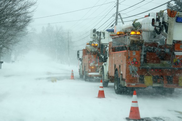 utility trucks doing repairs during winter storm