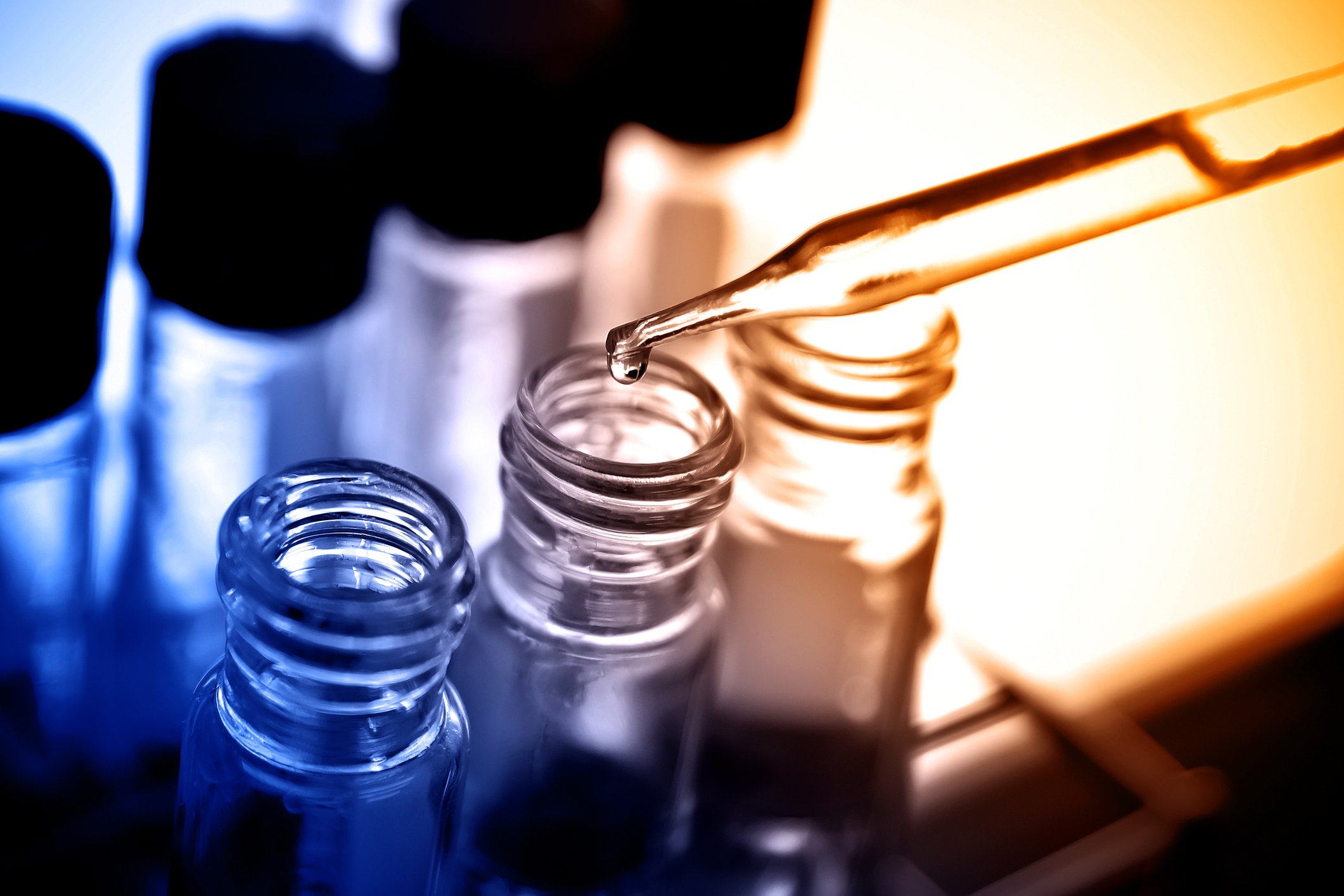 A dropper placing liquid into a narrow test tube. 