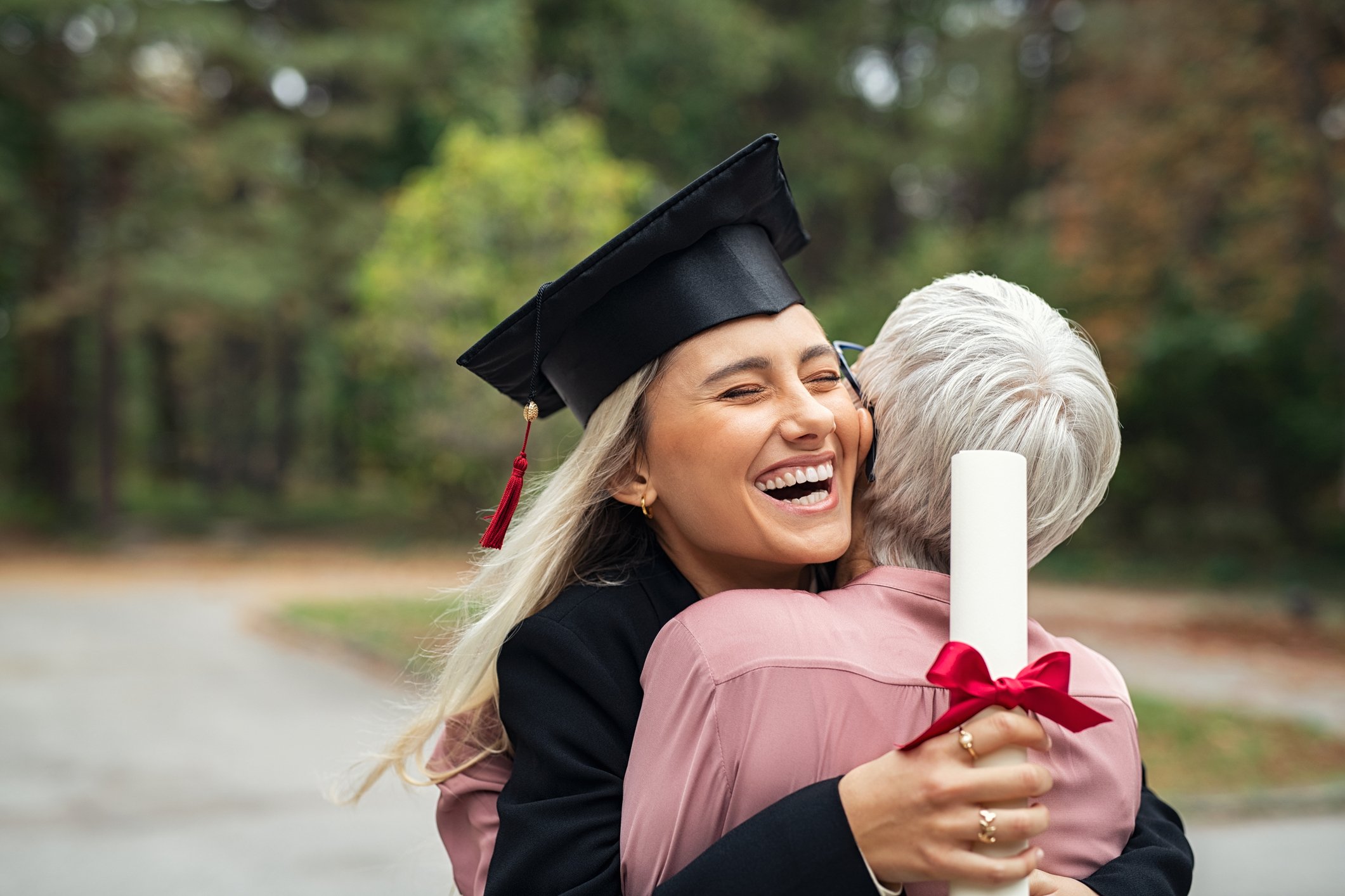 College graduate hugging mom.