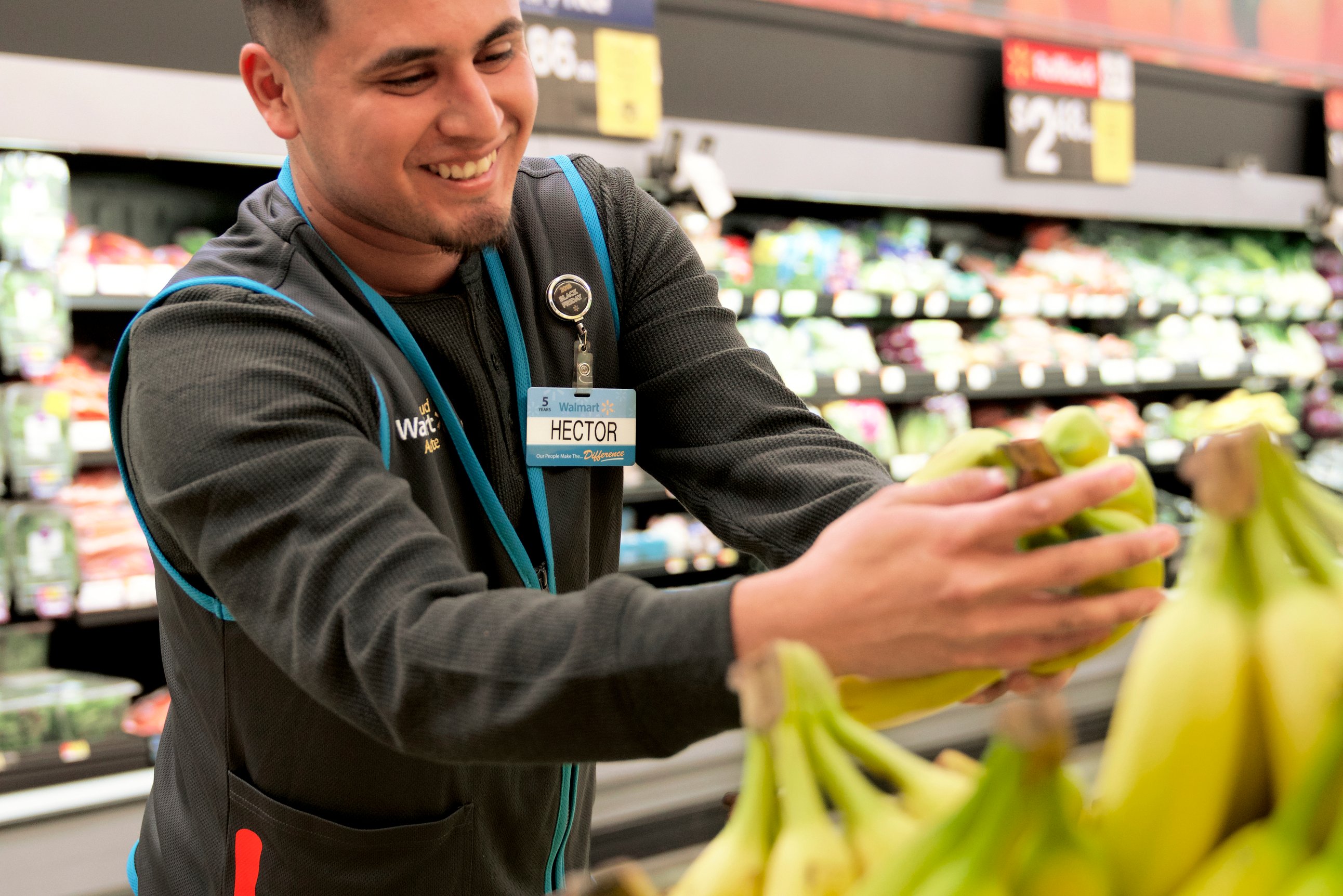 Walmart employee working in the produce aisle.
