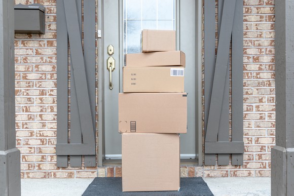 Stack of boxes in front of a residential front door. 