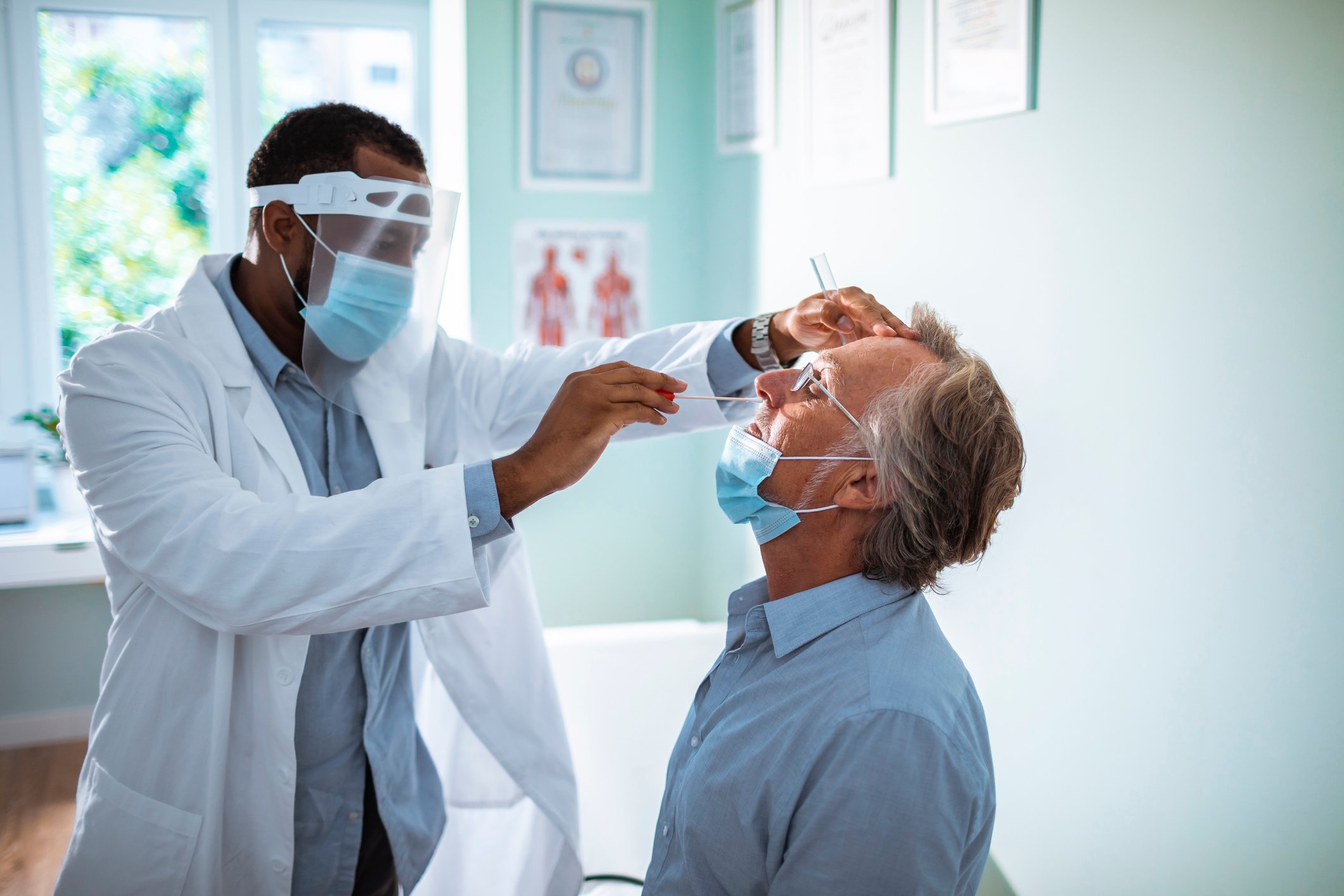 Physician holding a nasal swab in a patient's nose