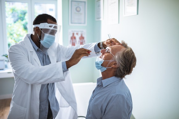 Physician holding a nasal swab in a patient's nose