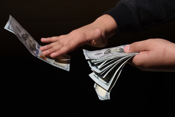 Hands holding hundred dollar bills 