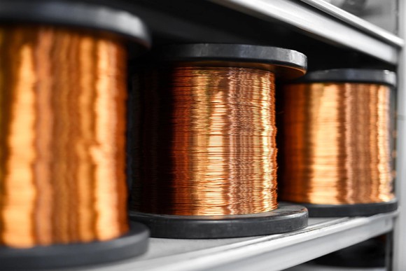 Three spools of copper wire on a shelf.