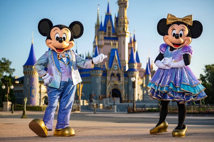 Mickey and Minnie dressed in new duds for the fiftieth anniversary of Disney World. They are in front of the Magic Kingdom's Cinderella Castle.