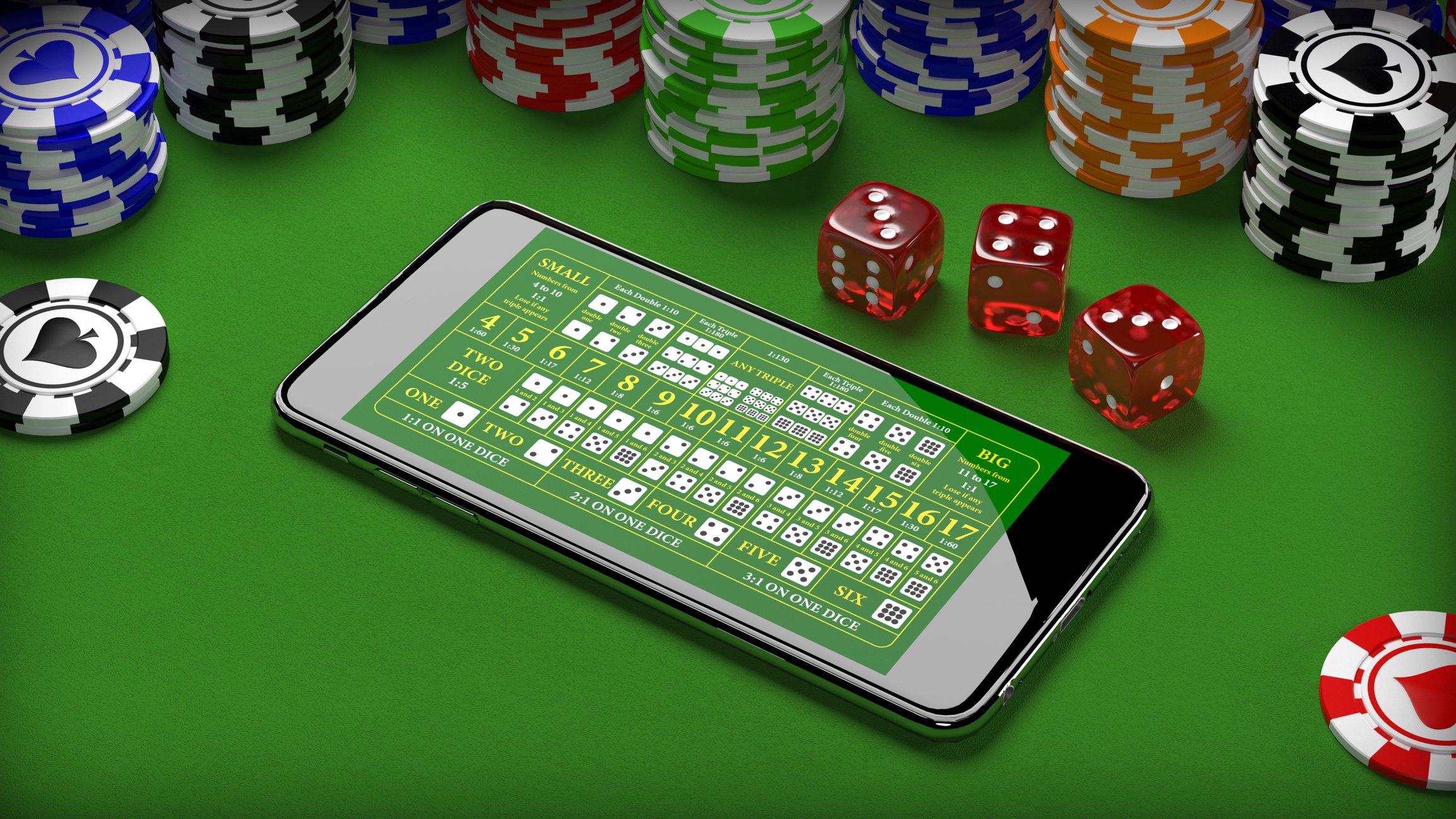 A smartphone with card icons on its screen, on a green baize tabletop surrounded by poker chips and dice.