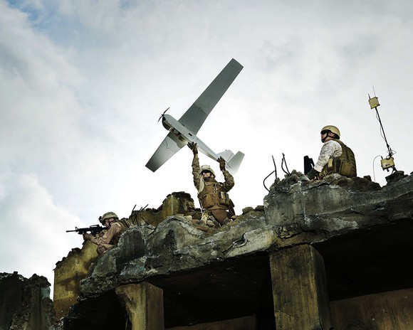 A soldier launches a hand-held AeroVironment drone.