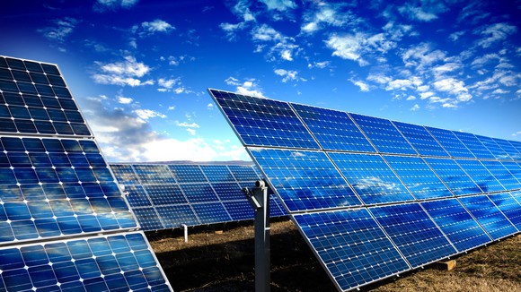 Solar panels with a bright blue sky in the background. 