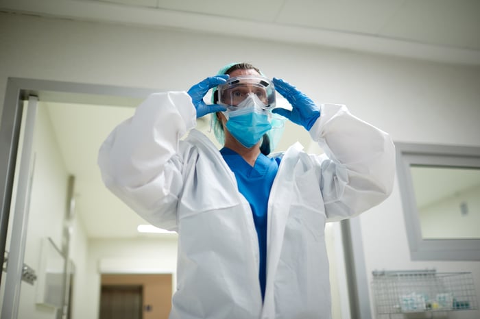 Doctor wearing gloves, a face mask, and protective glasses