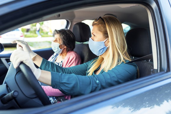 Senior citizen in vehicle with driver.