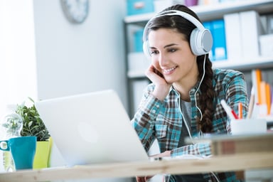 Girl with headphones using a laptop.