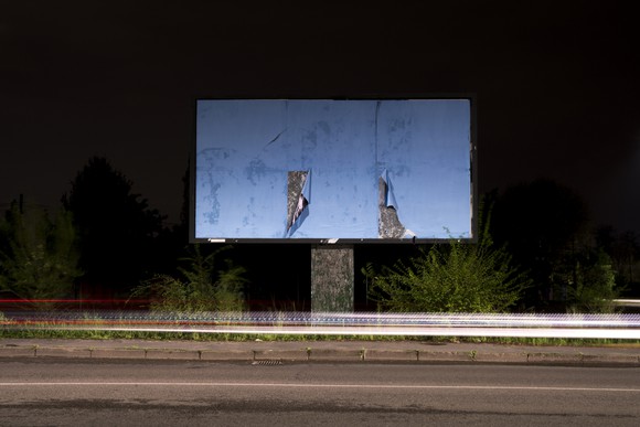 Abandoned billboard beside a road.