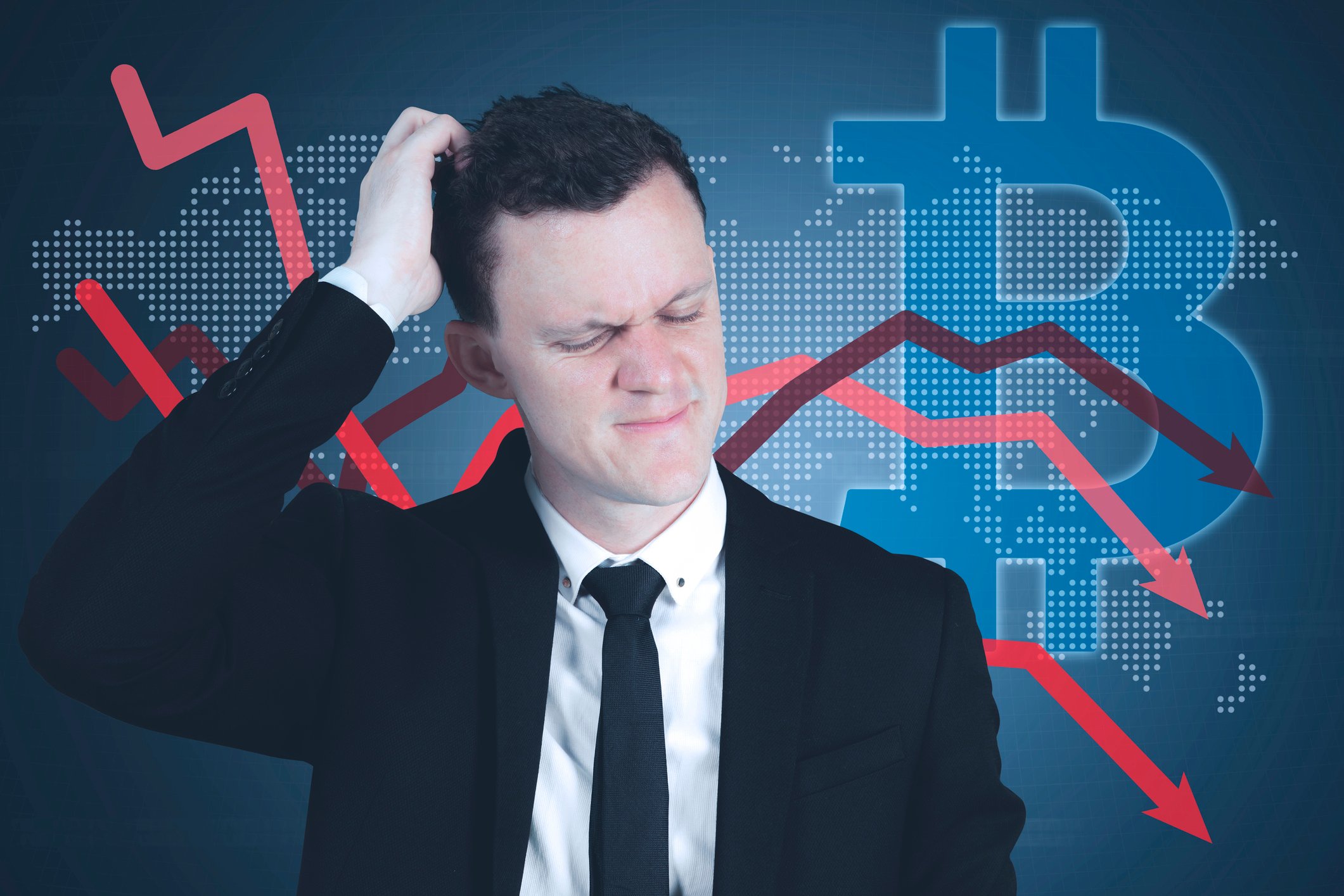 A businessman squints and scratches his head in front of a large Bitcoin symbol and several charting arrows trending down.