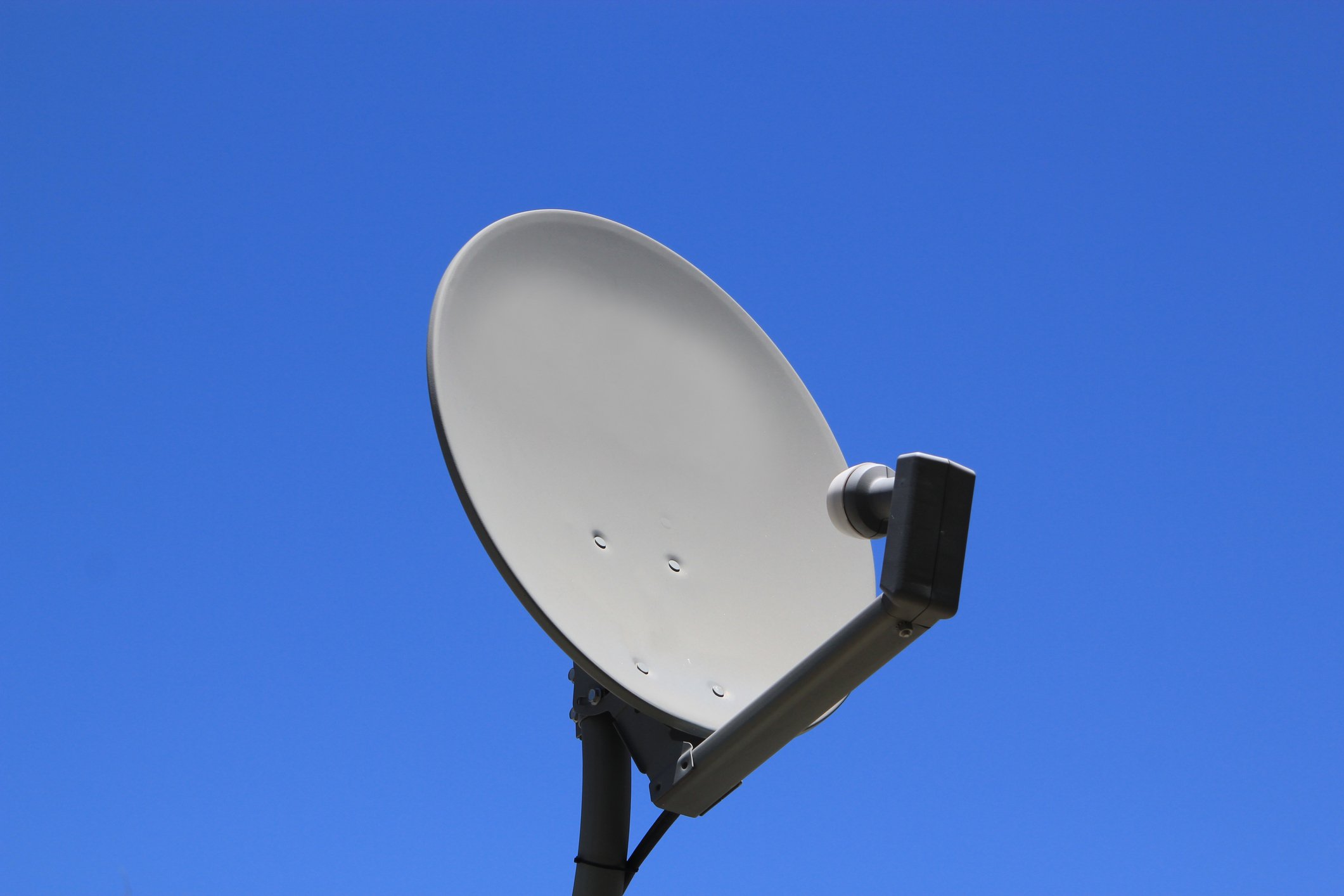 A satellite dish with a blue sky in the background.