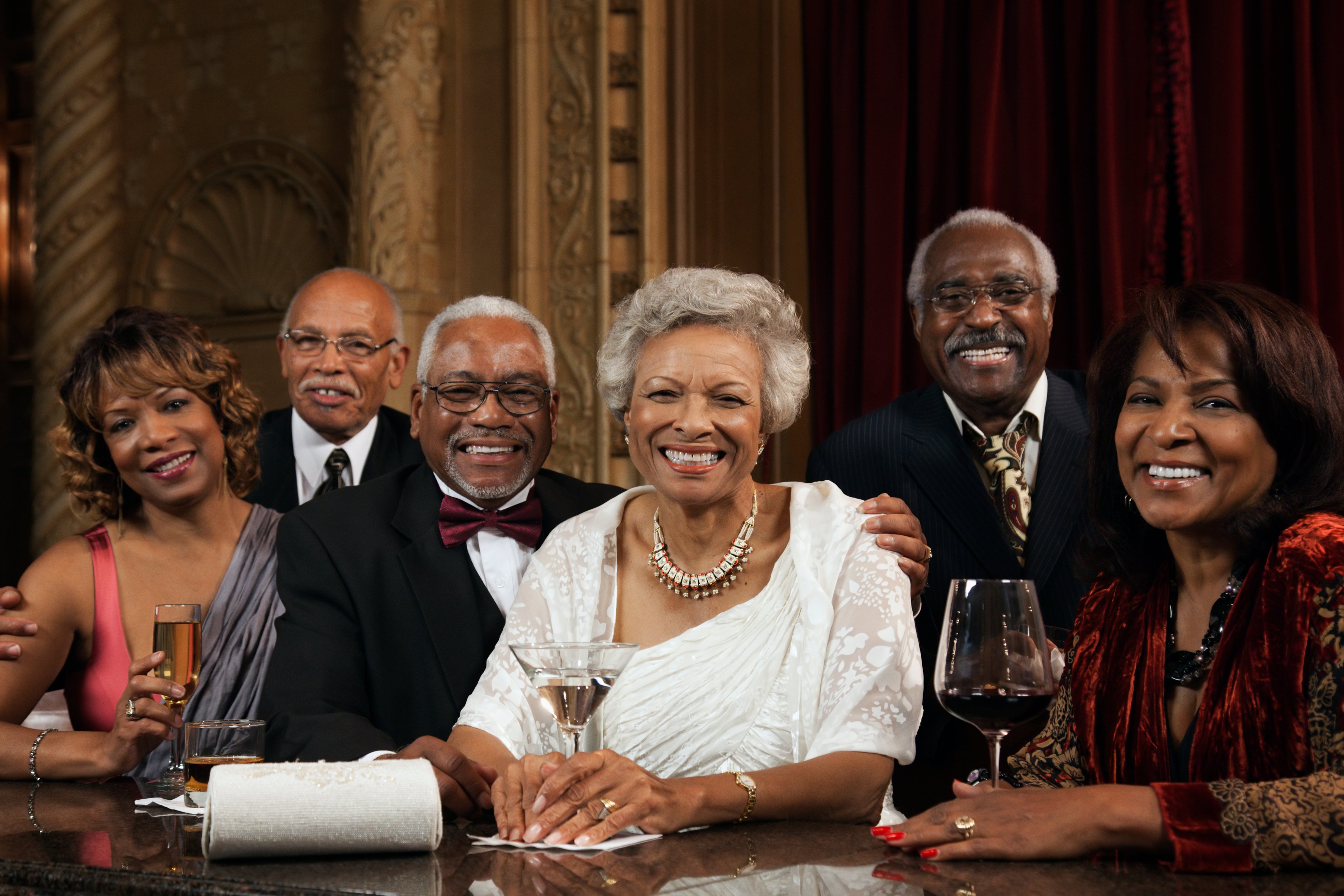 A group of older people are celebrating with wine.