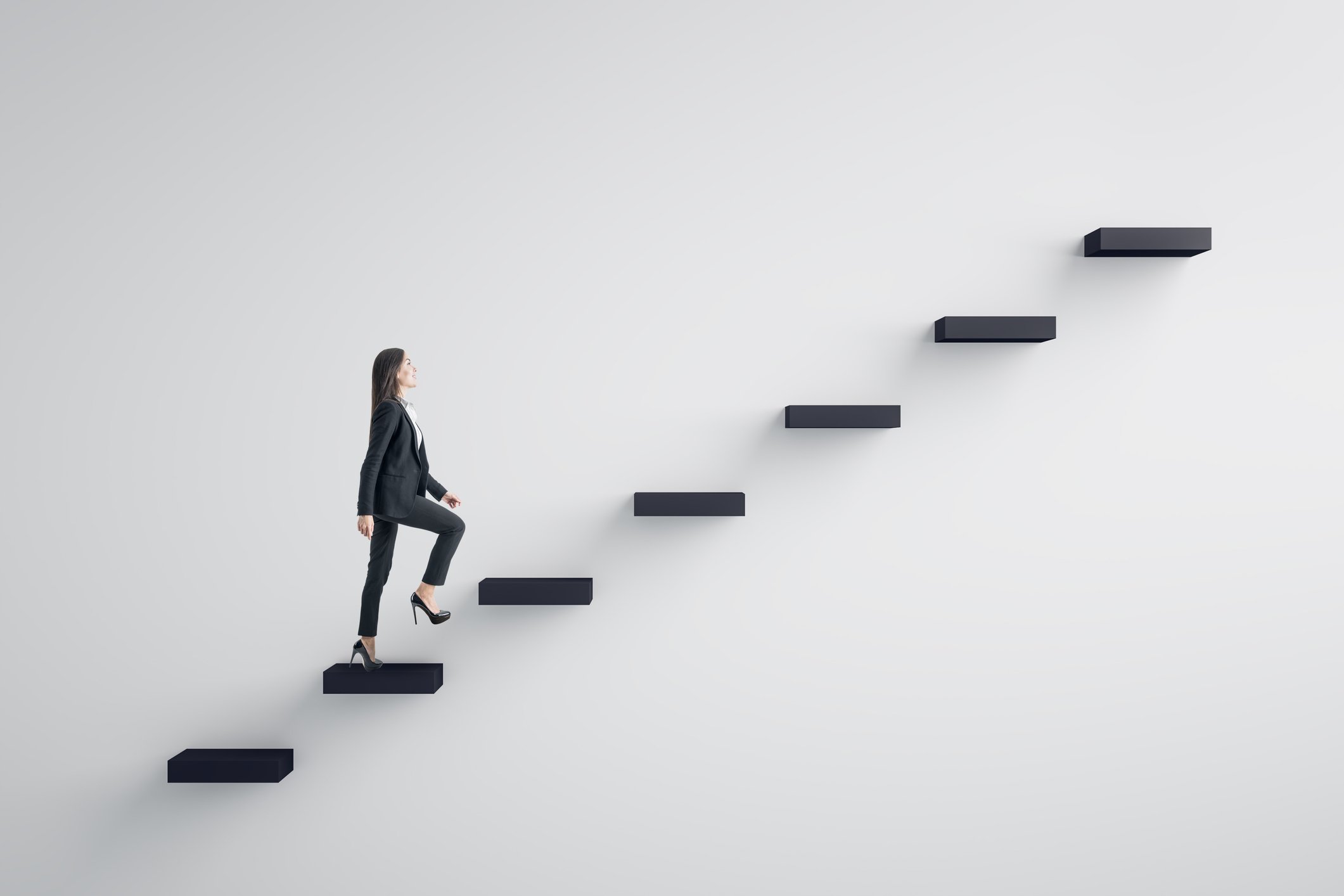 businesswoman climbing up stairs against white background