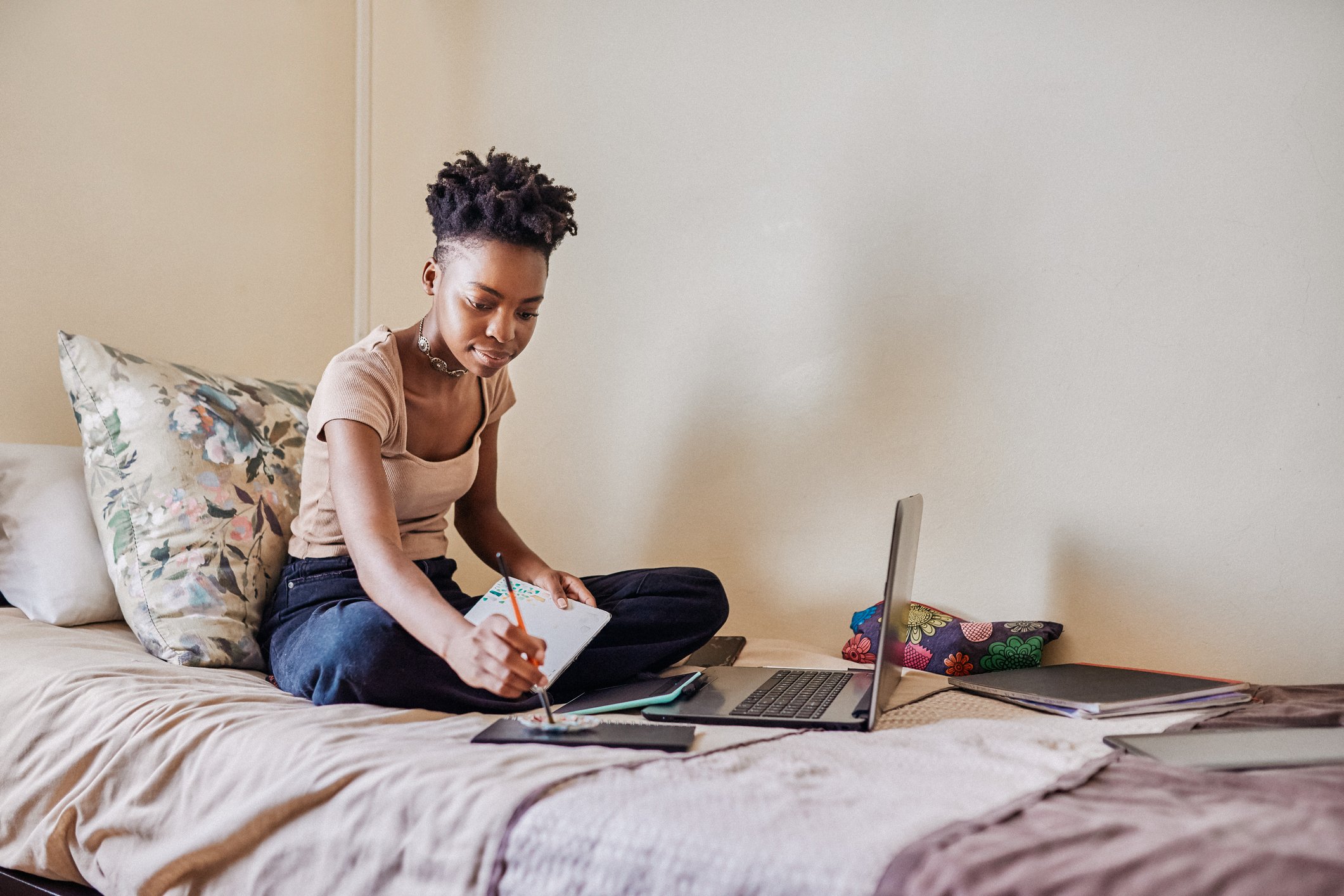 A woman painting and using a computer