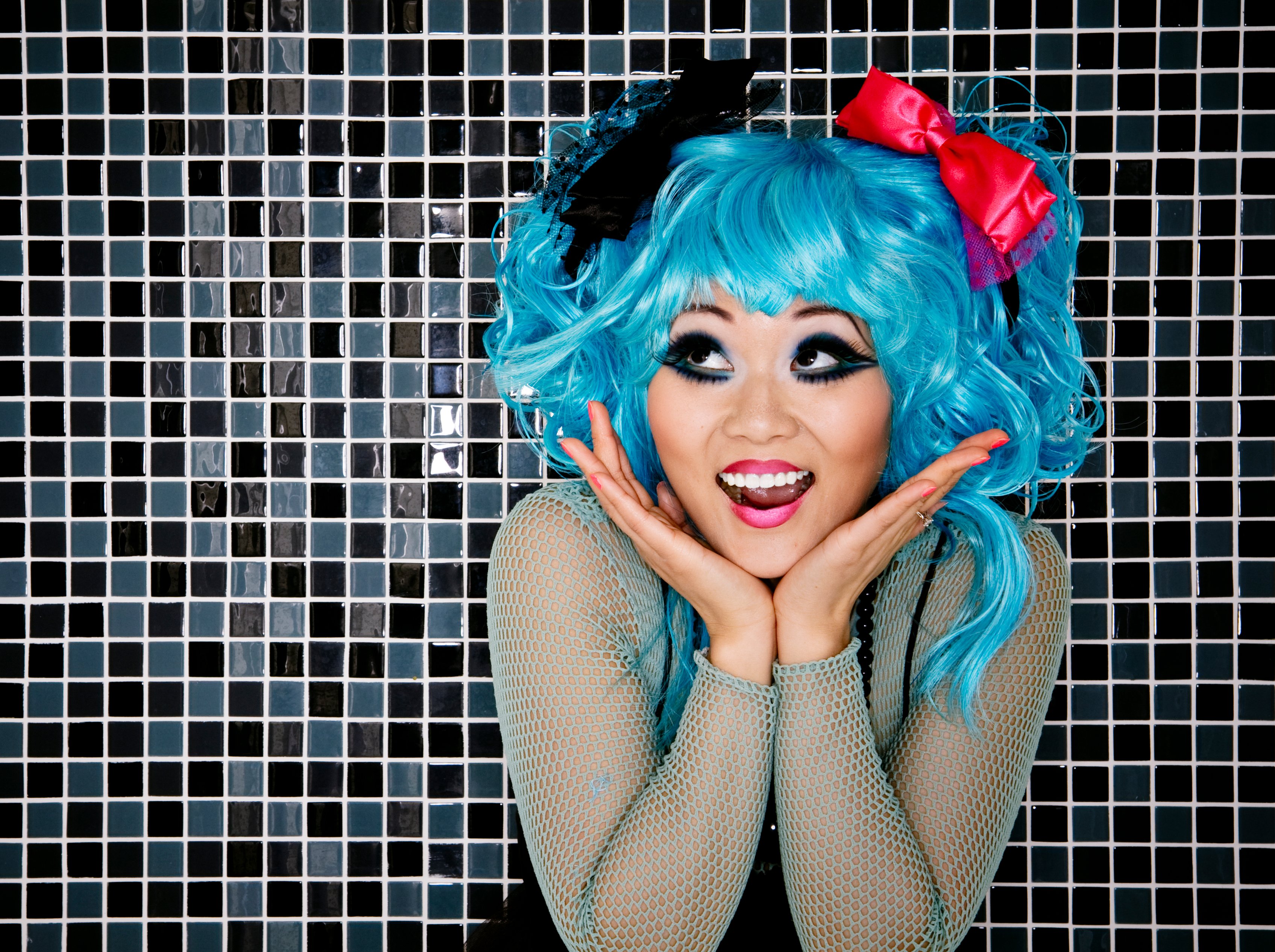 A girl dressed up as an anime character with blue hair.