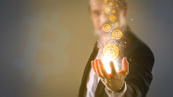 A man holding virtual Bitcoin tokens 
